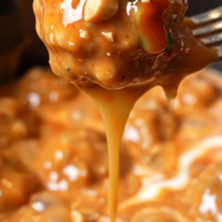 A close-up shot of creamy Bang Bang chicken meatballs in a white slow cooker