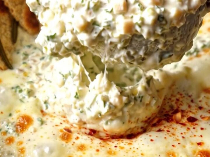 A rustic slow cooker filled with creamy Tuscan kale and Asiago dip, served with crispy flatbread.