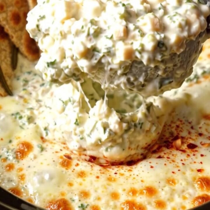 A rustic slow cooker filled with creamy Tuscan kale and Asiago dip, served with crispy flatbread.
