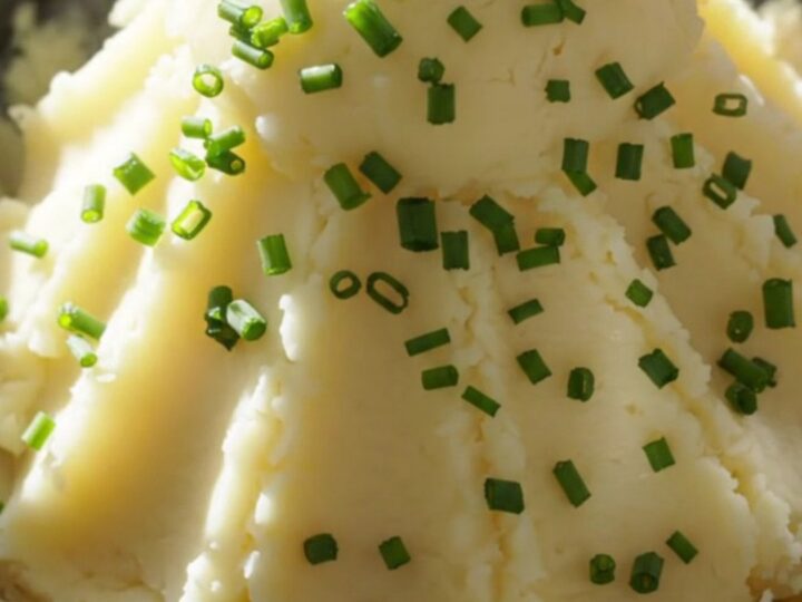 A close-up view of velvety mashed potatoes in a cream-colored stoneware slow cooker