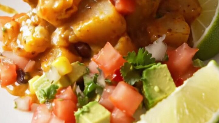 A steaming scoop of smoky chipotle cheddar fiesta potatoes topped with fresh cilantro and avocado in a rustic bowl.