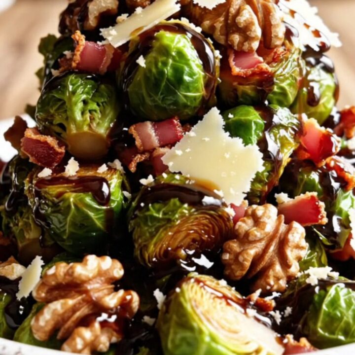 A copper slow cooker filled with caramelized balsamic Brussels sprouts topped with walnuts and parmesan.