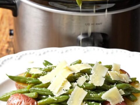 A rustic platter featuring tender baby red potatoes and crisp green beans tossed in a glossy garlic butter sauce and topped