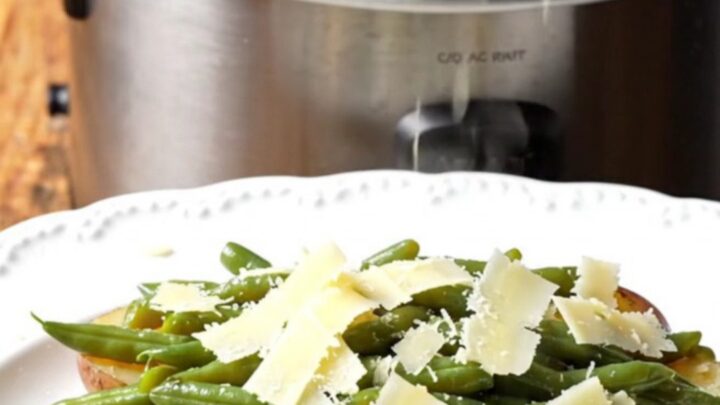 A rustic platter featuring tender baby red potatoes and crisp green beans tossed in a glossy garlic butter sauce and topped