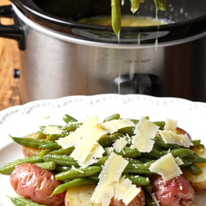 A rustic platter featuring tender baby red potatoes and crisp green beans tossed in a glossy garlic butter sauce and topped