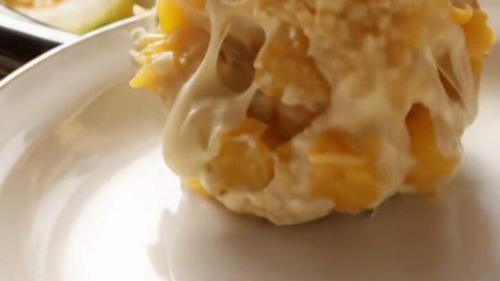 A close-up of a creamy Southern yellow squash casserole in a ceramic crockpot with a golden, buttery Ritz cracker topping.