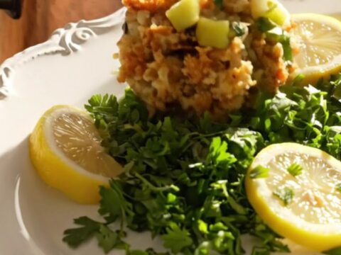 A steaming, golden-brown oyster and sage cornbread dressing served in a rustic heirloom platter.