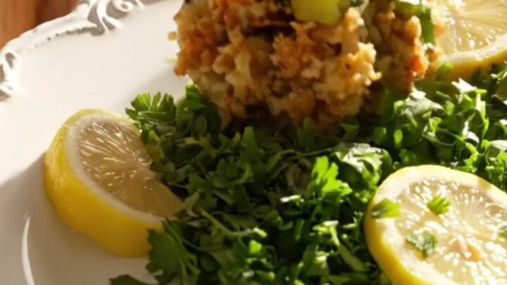 A steaming, golden-brown oyster and sage cornbread dressing served in a rustic heirloom platter.