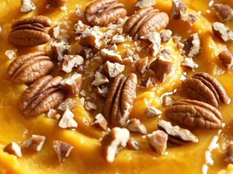 A warm bowl of silky maple brown butter mashed butternut squash topped with candied pecans.