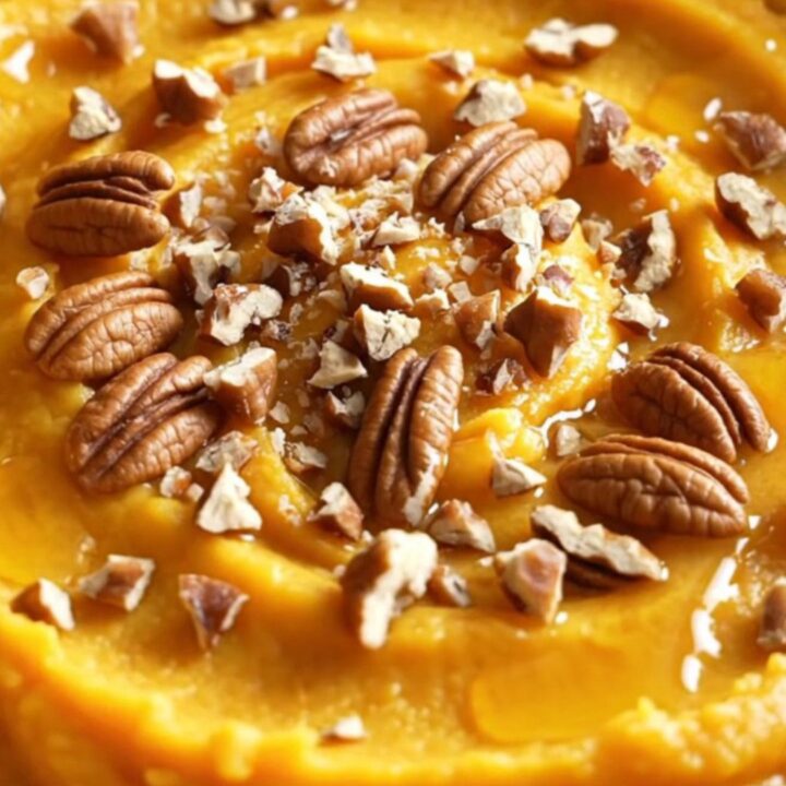 A warm bowl of silky maple brown butter mashed butternut squash topped with candied pecans.