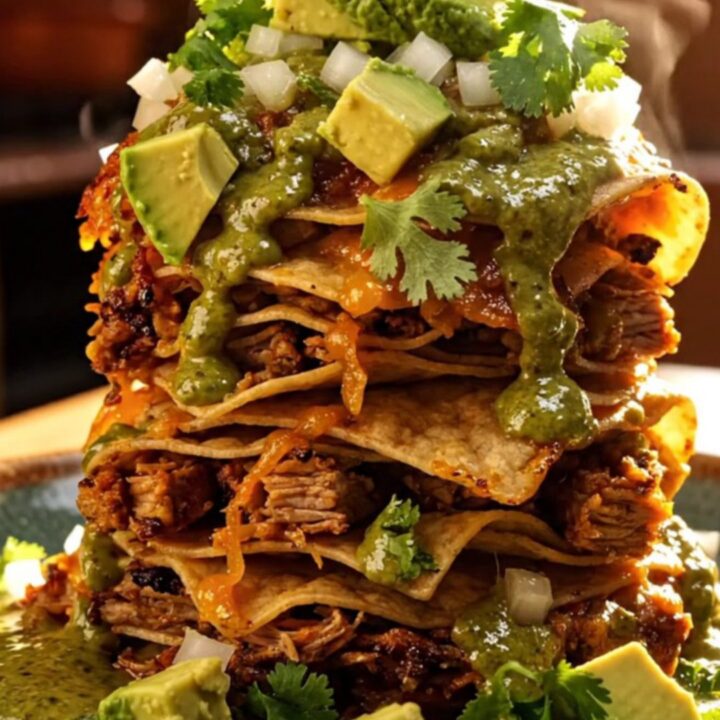 A steaming Crockpot filled with pulled pork, green chiles, and melted cheese.