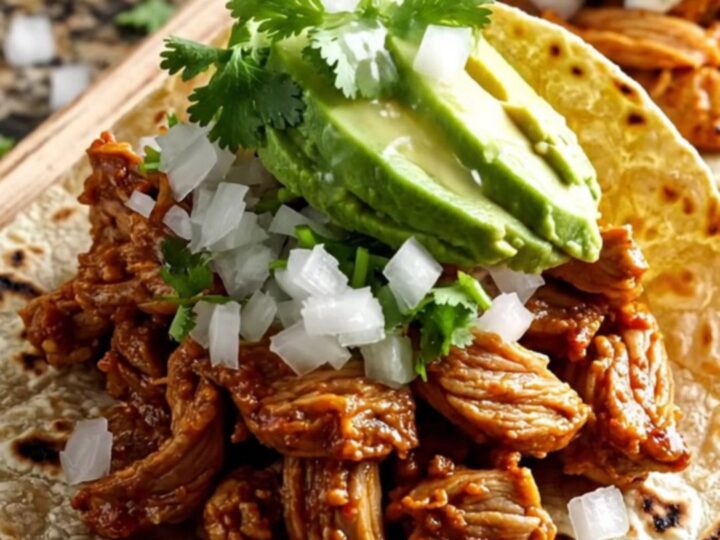A vibrant red slow cooker filled with tender Al Pastor pork, sweet pineapple chunks, and melted cheese.