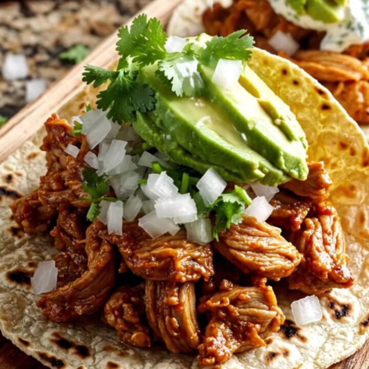 A vibrant red slow cooker filled with tender Al Pastor pork, sweet pineapple chunks, and melted cheese.