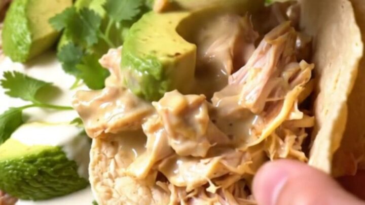 A rustic slow cooker filled with shredded chicken, roasted poblano strips, and a creamy, cheesy sauce.