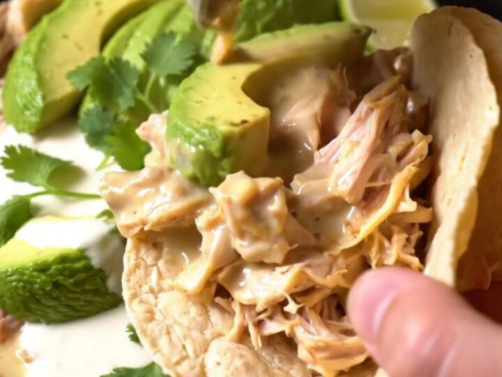 A rustic slow cooker filled with shredded chicken, roasted poblano strips, and a creamy, cheesy sauce.