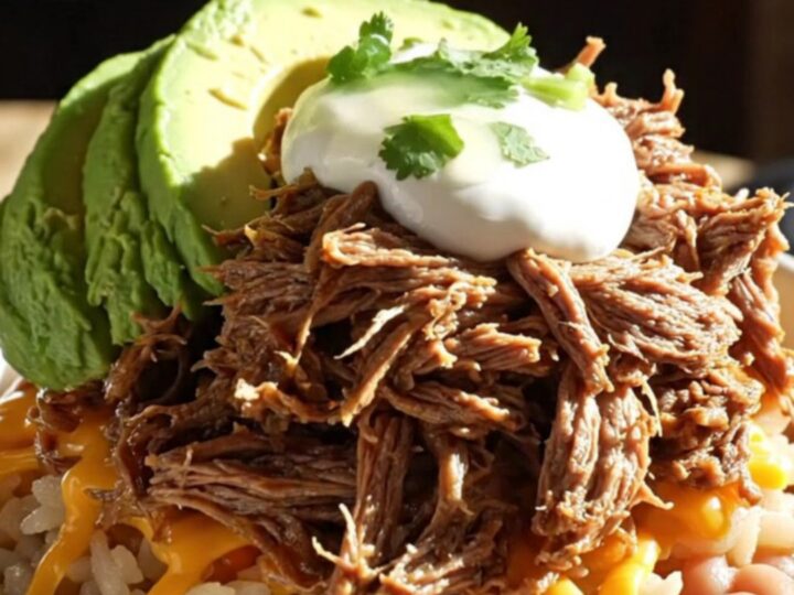 A vibrant burrito bowl featuring tender shredded beef machaca, Spanish rice, and fresh avocado.