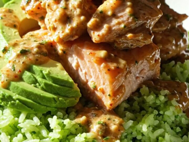 A ceramic slow cooker filled with flaky cooked salmon, sweet corn, and a creamy, smoky chipotle-lime sauce.
