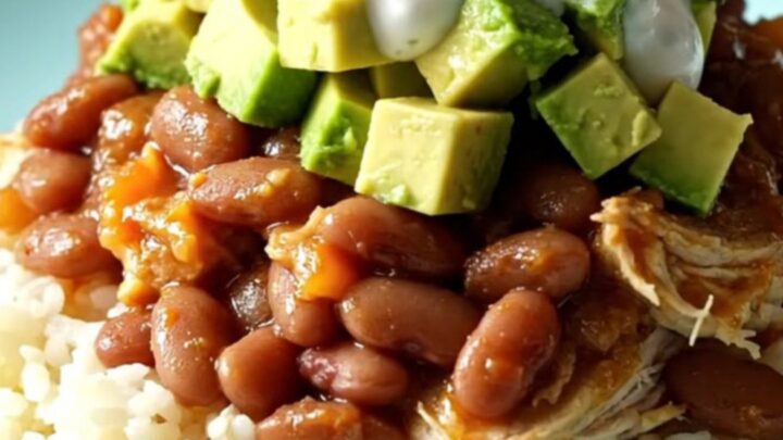A bright turquoise Crockpot filled with shredded chicken, pinto beans, and melted cheese in a sunny kitchen.