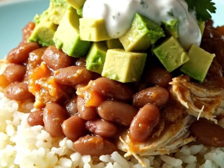 A bright turquoise Crockpot filled with shredded chicken, pinto beans, and melted cheese in a sunny kitchen.