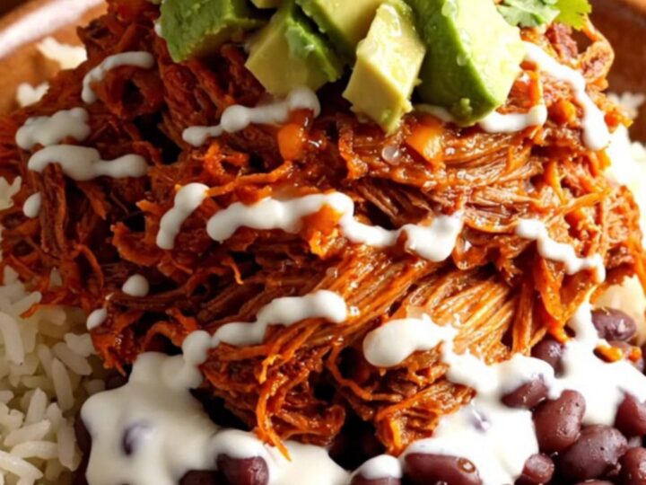 A vibrant burrito bowl featuring tender shredded pork al pastor, charred pineapple, and melted cheese.
