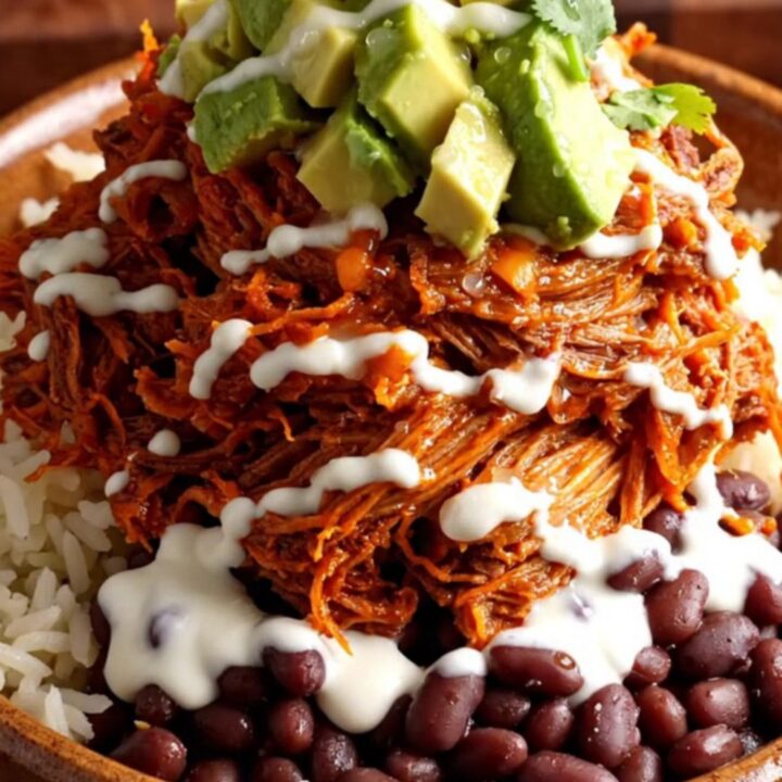 A vibrant burrito bowl featuring tender shredded pork al pastor, charred pineapple, and melted cheese.