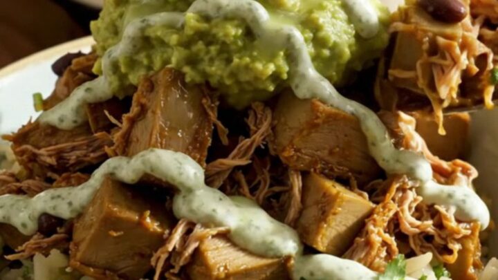 A vibrant burrito bowl featuring shredded jackfruit carnitas, black beans, and creamy avocado over cilantro-lime rice.