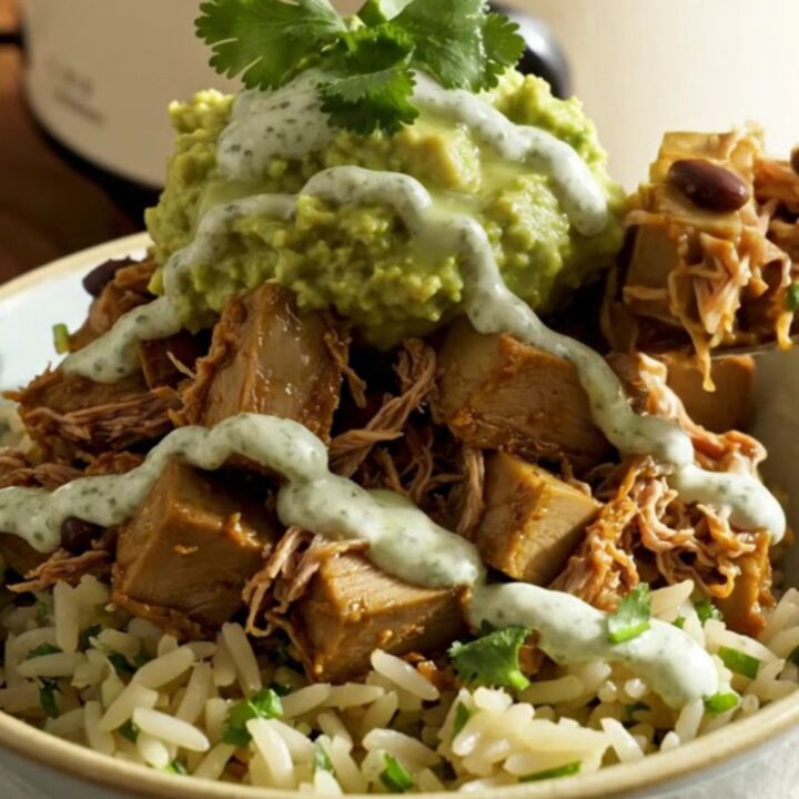 A vibrant burrito bowl featuring shredded jackfruit carnitas, black beans, and creamy avocado over cilantro-lime rice.
