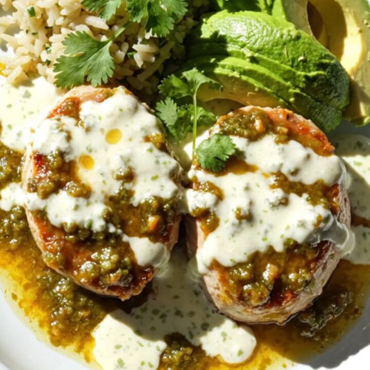 A close-up of tender pork tenderloin medallions topped with melted Monterey Jack cheese and garnished with fresh cilantro.