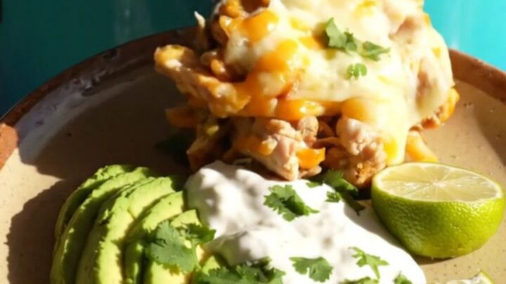 A turquoise slow cooker filled with a creamy, cheesy chicken and rice fajita casserole