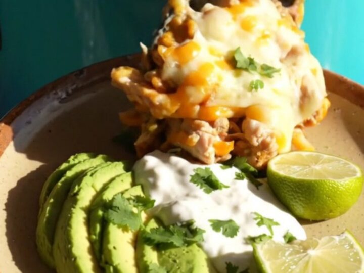 A turquoise slow cooker filled with a creamy, cheesy chicken and rice fajita casserole