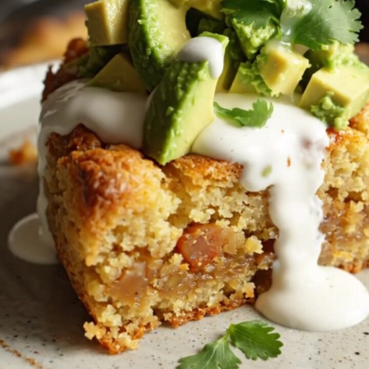 A rustic slow cooker filled with a golden, cheesy cornbread bake topped with fresh jalapeño slices and melted cheddar.